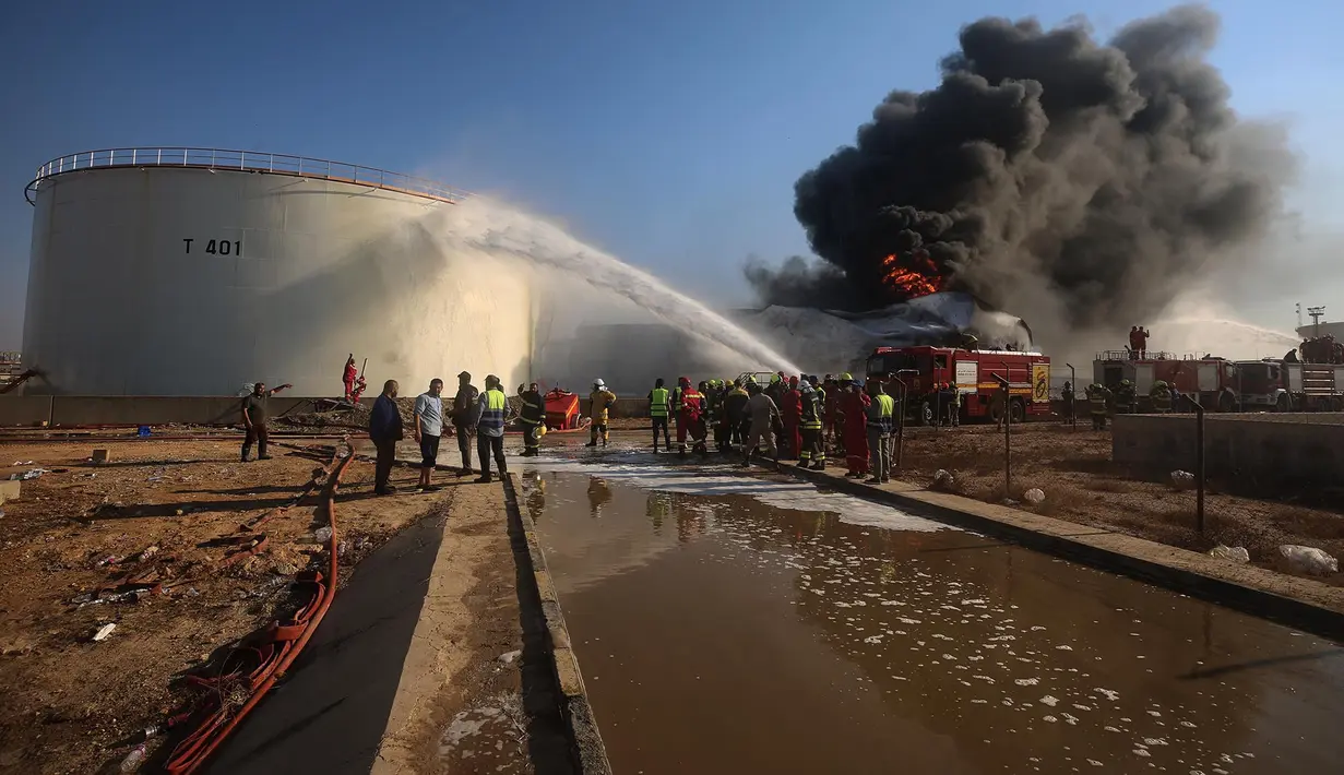 Petugas pemadam kebakaran berupaya memadamkan kebakaran di kilang minyak Zawiya setelah serangan pesawat nirawak di Zawiya, Libya, Selasa, 11 Agustus 2026. (AP/Yousef Murad)