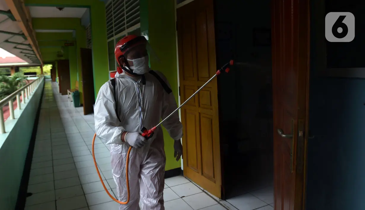 Petugas Palang Merah Indonesia (PMI) menyemprotkan cairan disinfektan di SMA 70 Jakarta, Kamis (27/1/2022). Pemprov DKI Jakarta mencatat ada 90 sekolah ditutup sementara akibat ditemukannya kasus COVID-19 varian Omicron yang tersebar di lima kota administrasi DKI Jakarta. (merdeka.com/Imam Buhori)