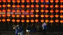 Orang-orang foto di depan dekorasi selama Festival Pertengahan Musim Gugur di taman Victoria di Hong Kong, Selasa (21/9/2021).  Festival ini jatuh pada hari ke-15 bulan ke-8 penanggalan Imlek. (AP Photo/Vincent Yu)