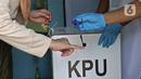 Petugas menandai jari warga dengan tinta usai mencoblos saat Pilkada Depok di TPS 56, Mekarjaya, Depok, Rabu (9/12/2020). TPS 56 menggunakan tema kesehatan untuk menarik warga menggunakan hak pilih dan mengingatkan protokol kesehatan di masa Pandemi COVID-19.  (Liputan6.com/Herman Zakharia)