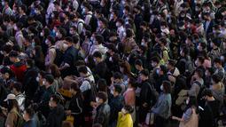 Pelancong yang mengenakan masker mengantre kereta di sebuah stasiun di Guangzhou di Provinsi Guangdong, China, Jumat (28/1/2022). Warga China melakukan perjalanan ke kampung halaman mereka untuk Tahun Baru Imlek, hari libur keluarga terbesar di negara itu. (Chinatopix via AP)