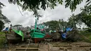 Para pekerja berjalan melewati kapal-kapal yang sedang diperbaiki di galangan kapal di tepi Sungai Yangon, yang terletak di pinggiran Yangon, Myanmar (30/7/2019). (AFP Phot/Sai Aung Main)