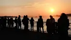 Sejumlah warga menikmati taman Brooklyn saat matahari terbenam di mana suhu mencapai hampir 70 derajat di New York City (21/2). Cuaca New York akan berubah kembali ke musim dingin dengan suhu yang diperkirakan 30 derajat. (AFP Photo/Spencer Platt)
