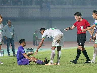 Wasit asal Jepang, Yusuke Araki, memperingatkan pemain Persita Tangerang, Ambrizal Umanailo, agar segera bangkit setelah terjatuh saat melawan Persikabo 1973 pada laga pekan ke-22 BRI Liga 1 2023/2024 di Stadion di Indomilk Arena, Tangerang, Minggu (10/12/2023). Persita menang dengan skor 2-1. (Bola.com/M Iqbal Ichsan)