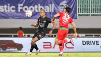 Pemain Dewa United, Alex Martins (kiri) dijaga ketat oleh pemain Persebaya Surabaya, Riswan Lauhin dalam pertandingan Dewa United melawan Persebaya Surabaya pada pekan ke-24 BRI Liga 1 di Stadion Pakansari, Kabupaten Bogor, Jumat (21/2/2025) malam WIB. (Bola.com/Abdul Aziz)