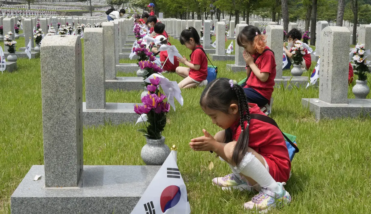 <p>Murid-murid taman kanak-kanak berdoa di depan nisan tentara yang gugur selama Perang Korea 1950-1953 pada malam Memorial Day Korea Selatan di Pemakaman Nasional, Seoul, Korea Selatan, Senin (5/6/2023). Memorial Day di Korea Selatan diperingati setiap tanggal 6 Juni tiap tahunnya. (AP Photo/Ahn Young-joon)</p>