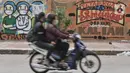 Pengendara melintas di depan mural dukungan untuk tim medis Covid-19 di kawasan Sunter, Jakarta, Rabu (27/5/2020). Mural tersebut sebagai bentuk dukungan untuk tim medis penanganan Covid-19 sekaligus mengingatkan masyarakat agar taat mengikuti aturan PSBB. (merdeka.com/Iqbal S. Nugroho)