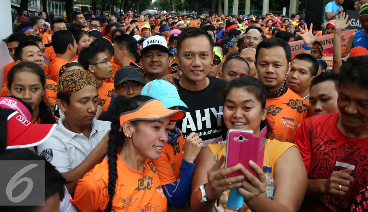 Calon Gubernur DKI Jakarta Agus Harimurti Yudhoyono berfoto selvie dengan warga Jakarta saat mengikuti kompetisi lari di CFD kawasan Senayan, Minggu (2/10). (Liputan6.com/Johan Tallo)