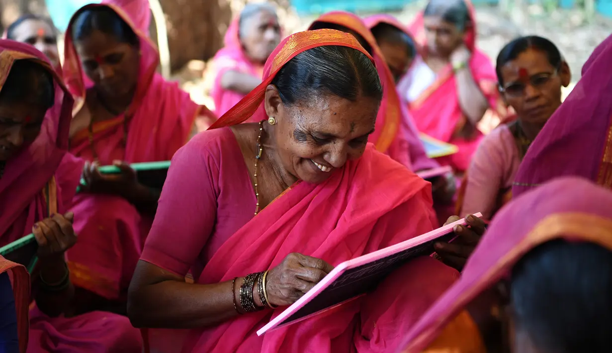 Ekspresi seorang nenek, Savita Deshmukh (62) selama belajar di Sekolah Aajibaichi Shaala, Desa Fangane, India, pada 1 Maret 2017. Sekolah ini didirikan pada 2016 agar membuat nenek-nenek terbebas dari buta aksara. (AFP Photo / Indranil Mukherjee)