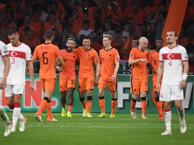 Striker Belanda, Memphis Depay (keempat kiri) berselebrasi dengan rekannya usai mencetak gol ke gawang Turki pada kualifikasi Grup G Piala Dunia Qatar 2022 di stadion Johan Cruijff Arena di Amsterdam (8/9/2021). Depay mencetak tiga gol dan mengantar Belanda menang atas Turki 6-1. (AFP/John Thys)