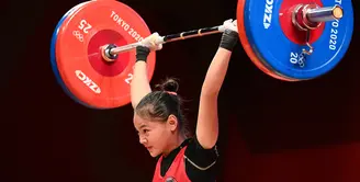 Lifter putri Indonesia Windy Cantika Aisah melakukan angkatan snatch dalam kelas 49 Kg Putri Grup A Olimpiade Tokyo 2020 di Tokyo International Forum, Sabtu (24/7/2021). Windy Cantika mempersembahkan medali pertama bagi Indonesia yakni perunggu dengan total angkatan 194 Kg. (Vincenzo PINTO/AFP)