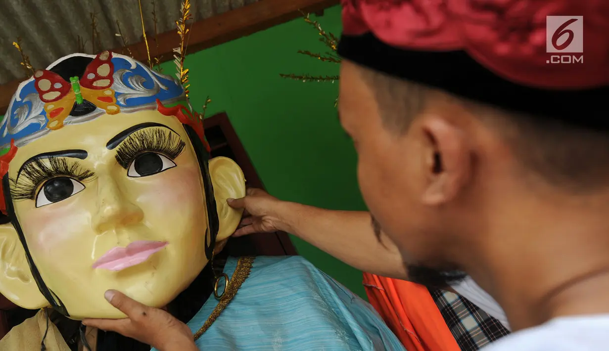 Perajin memasang kepala ondel-ondel Betawi ukuran besar saat proses pembuatan di Serpong, Tangerang Selatan, Banten, Rabu (10/10). Ondel-ondel dipasarkan dengan harga Rp 3 juta - Rp 5 juta per pasang. (Merdeka.com/Arie Basuki)