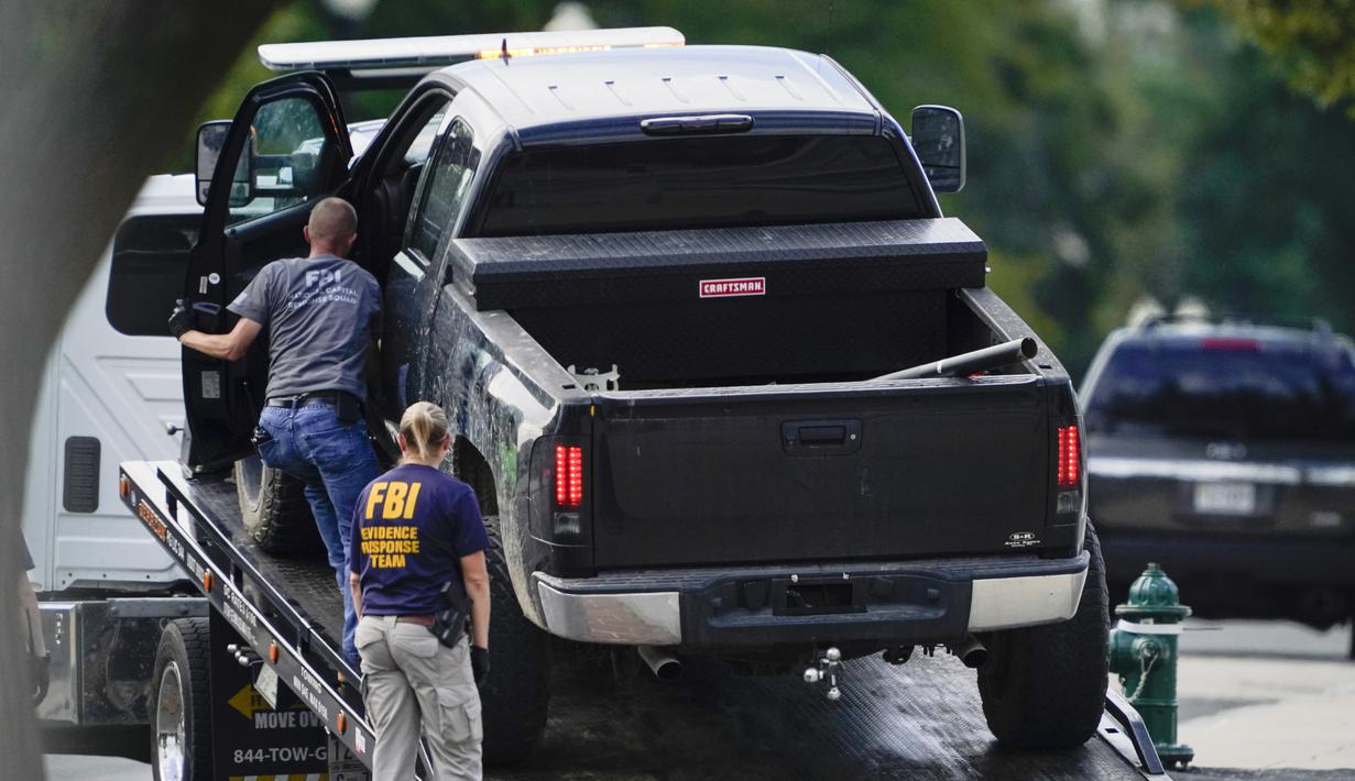 Pihak berwenang bersiap untuk menderek sebuah truk pickup yang dicurigai membawa bahan peledak dari trotoar di depan Perpustakaan Kongres AS, dekat gedung Capitol, Washington, Kamis (19/8/2021). Sumber penegak hukum AS mengatakan keberadaan bahan peledak belum dikonfirmasi. (AP Photo/Carolyn Kaster)