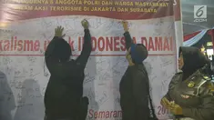 Sejumlah warga menandatangani spanduk saat tablig akbar di Simpang Lima, Kota Semarang, Minggu (13/5). Spanduk tersebut bentuk dukacita untuk korban teror di Mako Brimob, Jakarta beberapa waktu lalu dan teror bom gereja di Surabaya. (Liputan6.com/Gholib)