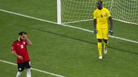 Reaksi penyerang Mesir Mohamed Salah (kiri) setelah gagal mencetak tendangan penalti ke gawang Senegal pada Kualifikasi Piala Dunia 2022 zona Afrika di Stade Me Abdoulaye Wade, Rabu (30/3/2022) dini hari WIB. Senegal menyingkirkan Mesir 3-1 lewat adu penalti. (AP Photo/Stefan Kleinowitz)