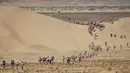 Para peserta bersaing dalam lomba lari internasional Marathon des Sables ke-32 tahap ketiga di Gurun Sahara, selatan Maroko, Selasa (11/4). Selama 6 hari, para peserta akan menempuh perjalanan dengan beragam rintangan. (JEAN-PHILIPPE KSIAZEK/AFP)