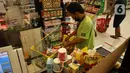 Pegawai merapikan belanjaan warga untuk kebutuhan bahan pokok akhir tahun di salah satu hypermarket, Jakarta, Sabtu (24/12/2022). Memasuki libur Natal dan Tahun Baru 2023, harga bahan pokok dan kebutuhan lainnya di supermarket masih stabil bahkan terdapat program promo. (merdeka.com/Imam Buhori)