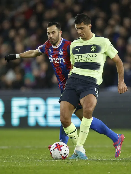Bek Manchester City, Rodrigo mengontrol bola dari kawalan pemain Crystal Palace, Luka Milivojevic selama pertandingan lanjutan Liga Inggris di stadion Selhurst Park, di London, Minggu (12/3/2023). Hasil ini membuat Manchester City memangkas jarak dengan pemuncak klasemen sementara Premier League,Arsenal. City mengoleksi 61 poin, beda 2 angka dari Arsenal. (AP Photo/David Cliff)