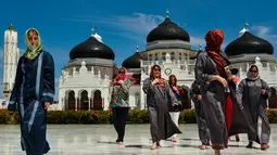 Turis asing mengenakan jilbab saat mengunjungi Masjid Agung Baiturrahman di Banda Aceh, Aceh pada 6 Agustus 2019. Selain sebagai tempat ibadah, Masjid Baiturahman juga menjadi tempat wisata bagi turis lokal dan mancanegara. (CHAIDEER MAHYUDDIN / AFP)