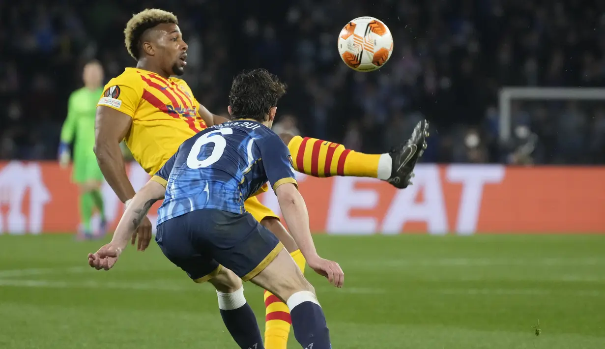 Penyerang Barcelona Adama Traore berebut bola dengan bek Napoli Mario Rui pada play-off fase gugur Liga Europa 2021/2022 di Stadion Diego Armando Maradona, Jumat (25/2/2022) dini hari WIB. Barcelona melaju ke babak 16 besar usai menang telak 4-2 di kandang Napoli. (AP Photo/Gregorio Borgia)