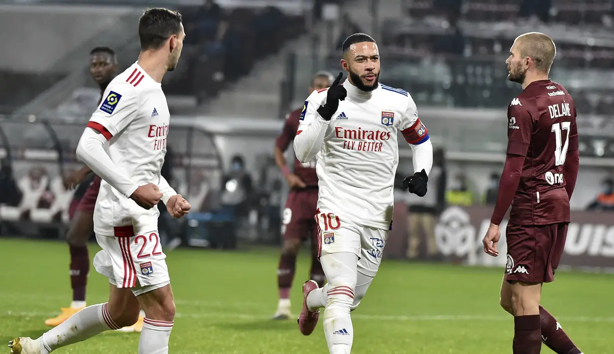 Selebrasi striker Lyon, Memphis Depay setelah mencetak gol ke gawang Metz pada laga Liga Prancis 2020/2021 di Saint Symphorien Stadium, Metz (6/12/2020). Satu setengah musim membela Manchester United, Memphis Depay hanya mencetak 7 gol dari 53 laga. Pada tengah musim 2016/2017 ia hijrah ke Lyon dan tampil tajam dengan torehan 76 gol dari 178 laga hingga akhir musim 2020/2021 sebelum akhirnya ditarik Barcelona. (AFP/Jean-Christophe Verhaegen)