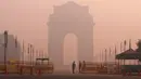 Petugas keamanan berjaga di depan India Gate yang diselimuti kabut tebal di New Delhi, India (31/10). Kabut tebal polusi ini menimbulkan kekhawatiran resiko berbagai penyakit yang berdampak pada penduduk kota New Delhi. (Reuters/Adnan Abidi)