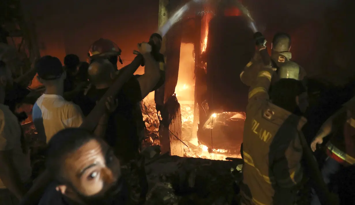 Petugas pemadam kebakaran memadamkan api di sebuah gedung setelah tangki bahan bakar meledak di lingkungan Tariq al-Jdide di Beirut (9/10/2020) waktu setempat.  Ledakan terjadi usai sebuah tangki BBM terbakar di distrik Tariq al-Jdide, Sabtu (10/10/2020). (AP Photo/Bilal Hussein)