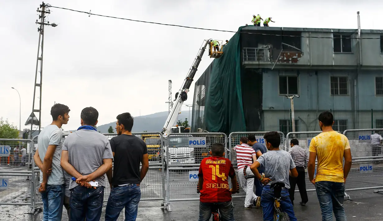 Sejumlah warga melihat kantor polisi yang rusak pasca diserang bom, Istanbul, Turki, Senin (10/8/2015). Sebuah truk bermuatan bahan peledak membombardir kantor polisi yang melukai tiga anggota dan tujuh warga sipil. (REUTERS/Huseyin Aldemir)