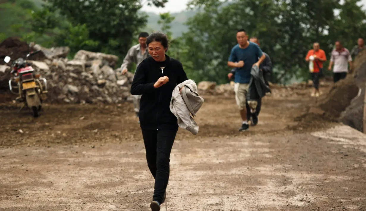 Warga tampak berlarian menyelamatkan diri beberapa saat setelah gempa mengguncang China, Minggu (3/8/14). (REUTERS/China Daily)