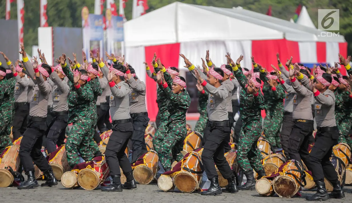 Prajurit TNI dan Polri berkolaborasi memainkan rampak gendang dalam HUT ke-73 Bhayangkara di Monas, Jakarta, Rabu (10/7/2019). HUT Bhayangkara ke-73 ini bertemakan ‘Dengan semangat Promoter, pengabdian Polri, untuk masyarakat, bangsa, dan negara. (Liputan6.com/Faizal Fanani)