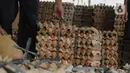 Pekerja memindahkan telur ayam dalam kemasan untuk dikirim menuju pasar di kawasan Karang Tengah, Kota Tangerang, Banten, Selasa (5/12/2023). (Liputan6.com/Angga Yuniar)