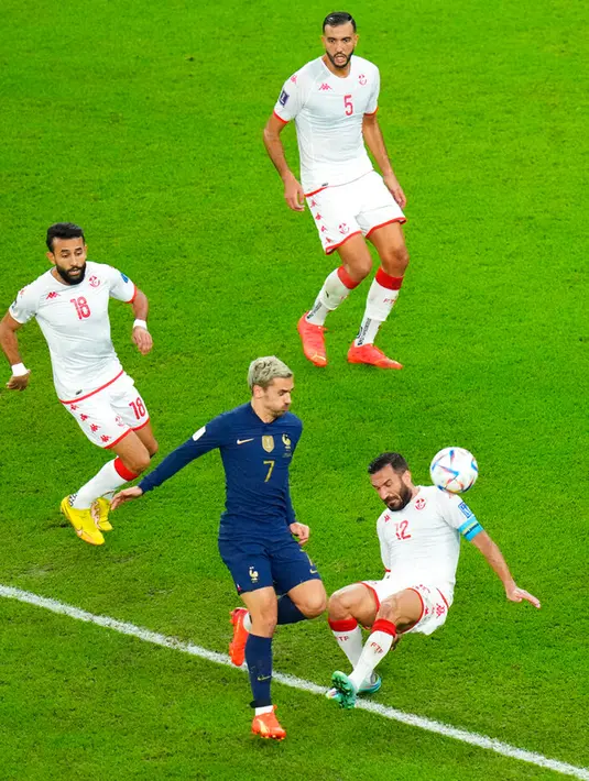 Pemain Prancis Antoine Griezmann (tengah) berebut bola dengan pemain Tunisia Ali Maaloul pada pertandingan sepak bola Grup D Piala Dunia 2022 di Stadion Education City, Al Rayyan, Qatar, 30 November 2022. Prancis menjuarai Grup D Piala Dunia 2022 meski kalah dari Tunisia 1-0. (AP Photo/Petr David Josek)