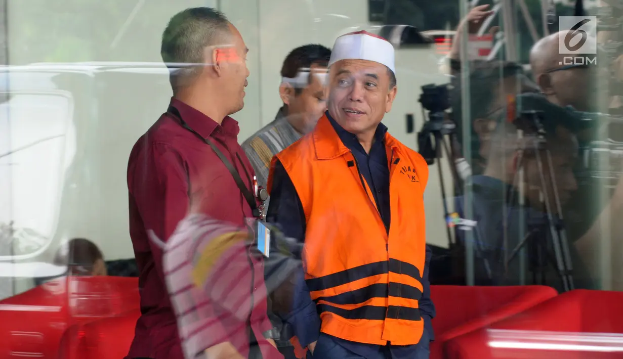 Tersangka Gubernur Aceh Irwandi Yusuf (kanan) usai menjalani pemeriksaan di Gedung KPK, Jakarta, Kamis (26/7). Irwandi Yusuf memakai rompi tahanan dan kopiah merah putih. (Merdeka.com/Dwi Narwoko)