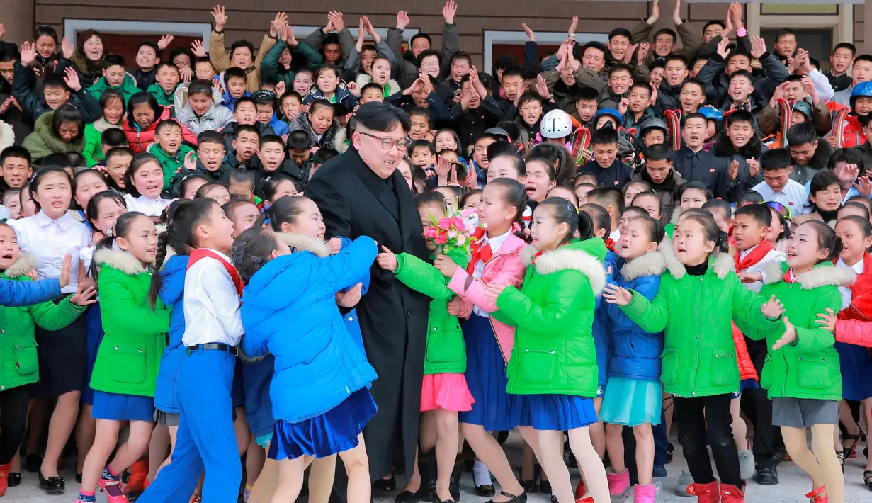 Sejumlah anak memeluk Pemimpin Korea Utara, Kim Jong-un saat berkunjung ke Samjiyon (28/11). Puluhan anak sekolah histeris kegirangan saat bertemu dengan pemimpin negara mereka. (REUTERS/KCNA)