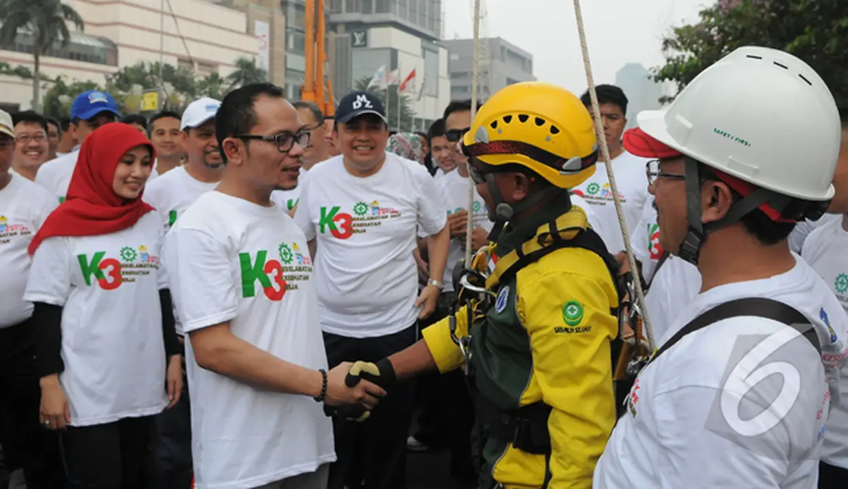Menteri Ketenagakerjaan Hanif Dhakiri menjabat tangan seorang petugas saat kampanye Keselamatan dan Kesehatan Kerja (K3) di Bundaran HI, Jakarta, Minggu (1/3/2015). (Liputan6.com/Herman Zakharia)