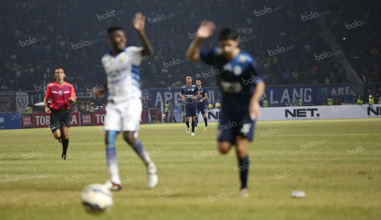 Yanto Basna (kiri) dan Esteban Vizcarra terlihat out of focus dalam tangkapan kamera saat berebut bola pada laga final Torabika Bhayangkara Cup 2016 di SUGBK, Jakarta, Minggu (3/4/2016). (Bola.com/Nicklas Hanoatubun)