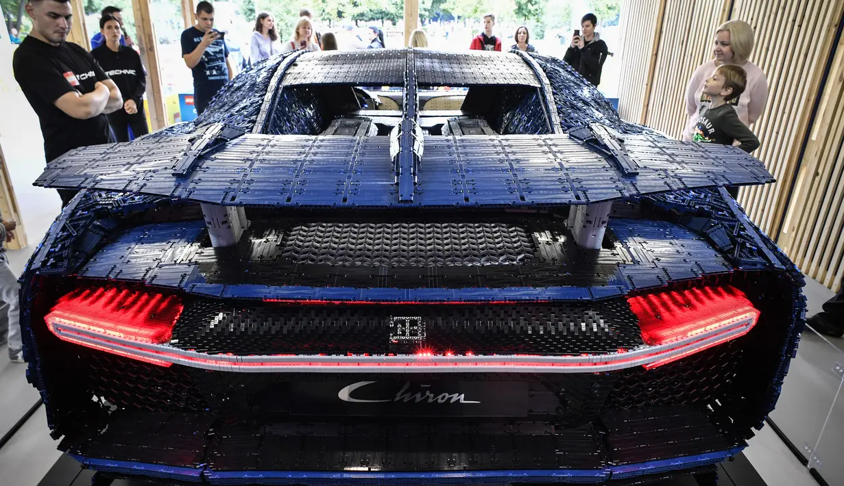 Pengunjung mengamati replika mobil Bugatti Chiron dari jutaan balok Lego Technic pada pameran di Taman Gorky Moskow, Selasa (23/7/2019). Satu juta keping LEGO ditambah bongkahan mesin yang dipasang tanpa tambahan lem, memakan waktu 13.438 jam, untuk dikembangkan dan dirakit. (Alexander NEMENOV/AFP)