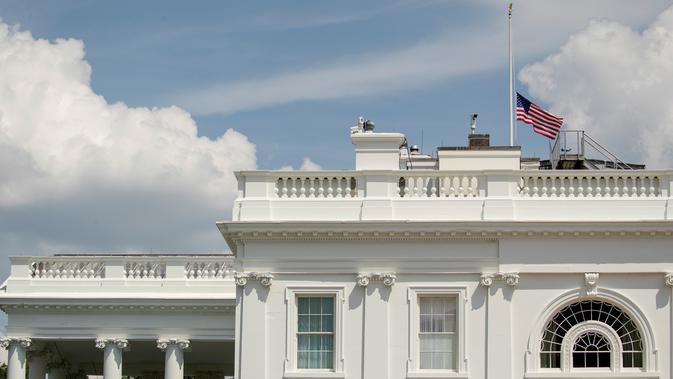 Bendera Amerika Serikat berkibar setengah tiang di Gedung Putih, Washington DC, Minggu (4/8/2019). Presiden Donald Trump memerintahkan pengibaran bendera setengah tiang di semua gedung pemerintah untuk mengenang korban tewas dalam dua penembakan massal di El Paso, Texas, dan Ohio. (AP/Andrew Harnik)