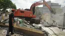 Petugas mengamati alat berat yang sedang meratakan rumah dinas para pensiunan PT KAI di Jalan Bungur Besar, Kompleks PJKA, Senen, Jakarta, Kamis (14/4). Tanah seluas 60.930 m2 itu akan digunakan untuk parkir kereta. (Liputan6.com/Gempur M Surya)