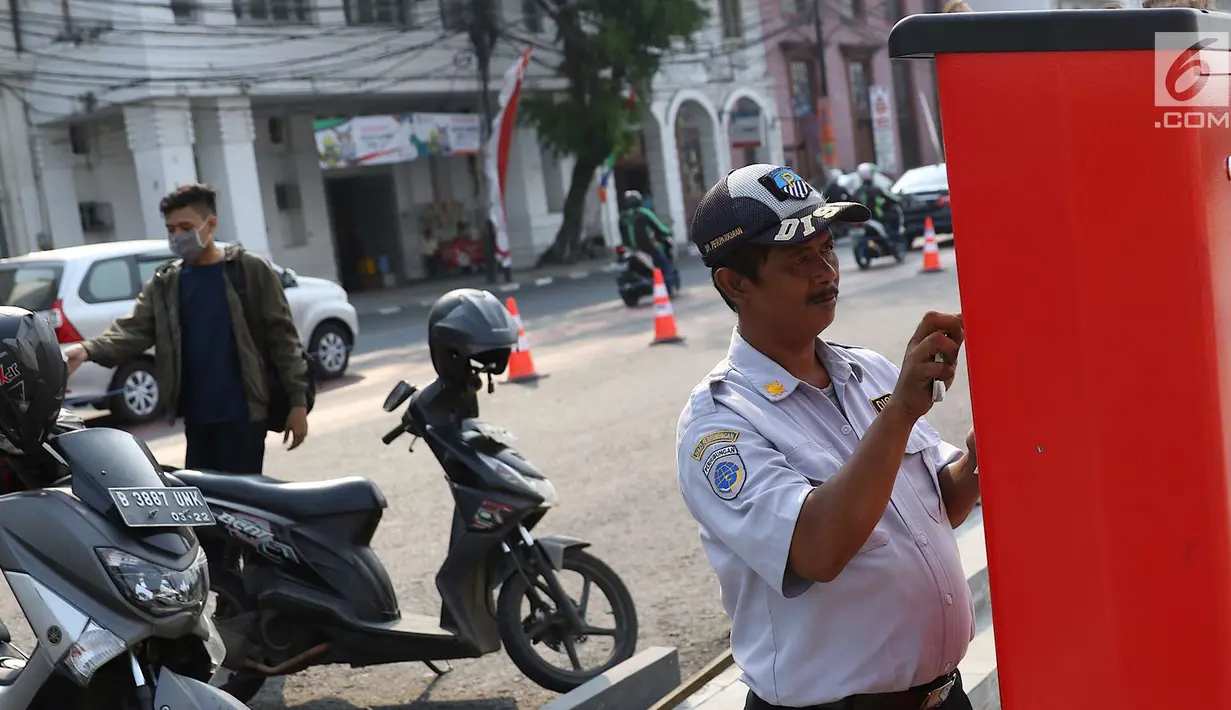 Petugas mengoperasikan mesin parkir meter di kawasan Kota Tua, Jakarta, Rabu (18/7). Sebanyak 13 Terminal Parkir Elektronik (TPE) dipasang di kawasan tersebut guna mengantisipasi membludaknya kendaraan yang parkir. (Liputan6.com/Immanuel Antonius)