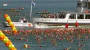 Para wisatawan melihat lomba berenang di Zurich, Swiss (24/8). Peserta mulai dari anak muda hingga orang tua bersaing menyebrangi Danau Zurich, Swiss. (REUTERS/Arnd Wiegmann)
