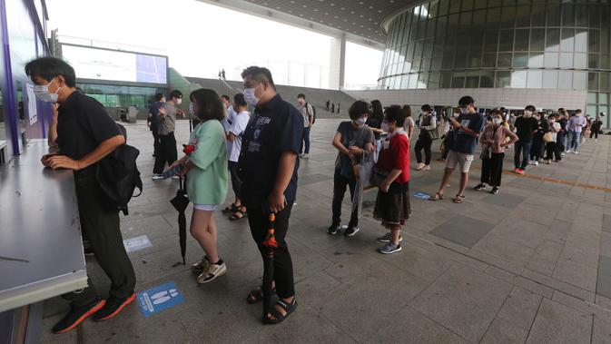 Pengunjung yang mengenakan masker antre untuk membeli tiket memasuki ruang pameran di Museum Nasional Korea di Seoul, Korea Selatan, Rabu (22/7/2020). Museum ini dibuka kembali pada Rabu (22/7) setelah ditutup selama dua bulan akibat pandemi corona Covid-19. (AP Photo/Ahn Young-joon)