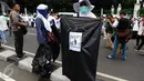 Relawan membawa kantong plastik bertuliskan "Throw A HOAX Here Please" di tengah aksi damai 4 November di Jakarta, Jumat (4/11). Mereka mengumpulkan sampah berupa bekas botol minuman dan bungkus nasi yang dibuang anggota ormas (Liputan6.com/Faizal Fanani)