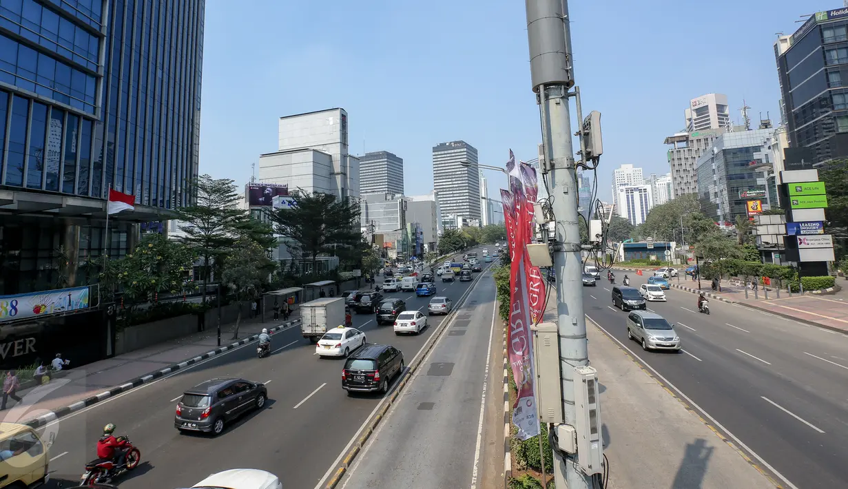 Sejumlah kendaraan bermotor berlalu lalang di kawasan Jalan Thamrin mengarah ke Sudirman, Jakarta, Kamis (18/6/2015). Pada hari pertama puasa Ramadan 1436 H, beberapa titik jalan terlihat lengang dan sepi dari aktivitas warga. (Liputan6.com/Faizal Fanani)
