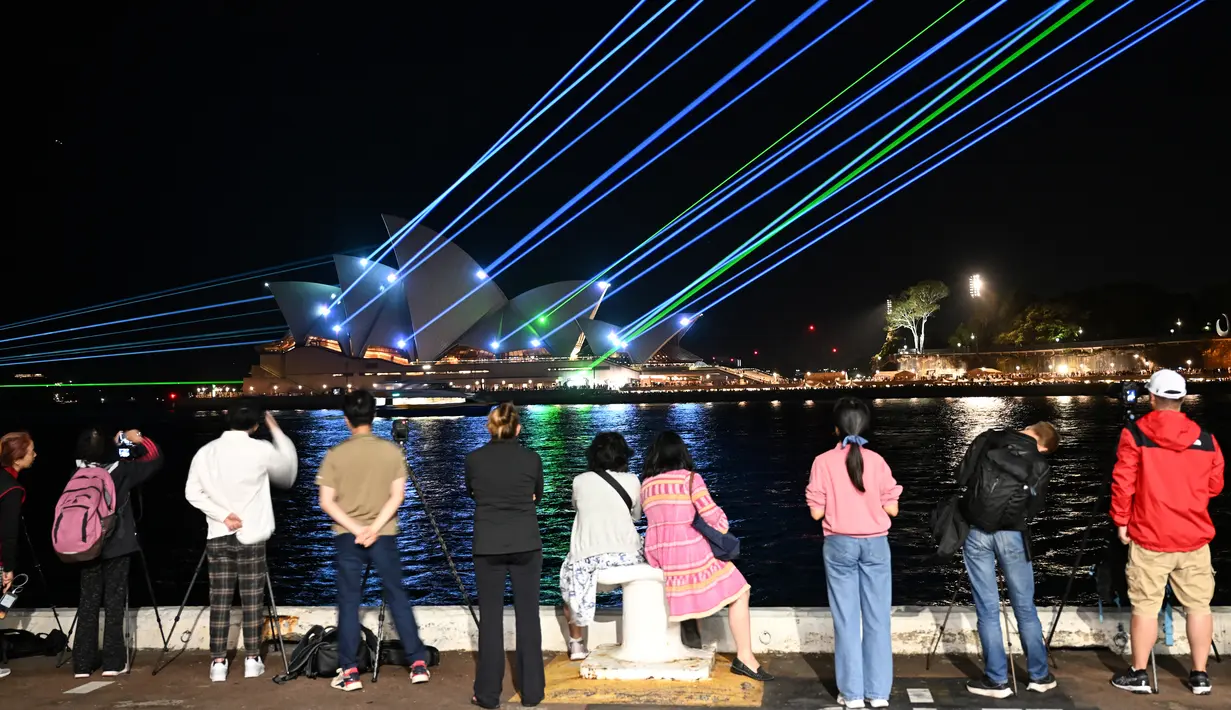 Sinar laser menerangi layar Sydney Opera House saat selama perayaan untuk menandai ulang tahunnya ke-50, Jumat (20/10/2023). (Saeed KHAN / AFP)