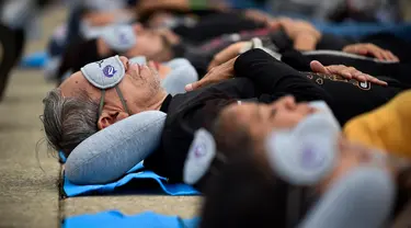 Orang-orang menikmati tidur siang saat menghadiri acara Hari Tidur Sedunia (World Sleep Day) di Monumento a la Revolution, Mexico City, Meksiko, pada 15 Maret 2024. (Rodrigo Oropeza/AFP)