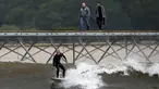 Seorang peselancar berselancar di Surf Snowdonia, Conwy, North Wales, Kamis (3/9/2015). Danau buatan untuk para penyuka selancar ini mengabiskan dana hingga ratusan Miliar dan telah dibuka pada tanggal satu Agustus lalu. (REUTERS/Andrew Yates)