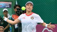 Petenis putri Indonesia, Aldila Sutjiadi berusaha mengembalikan bola ke arah petenis Thailand, Aunchisa Chanta pada pertandingan final tenis beregu putri SEA Games 2023 di Tennis Arena, Morodoc Techo National Stadium, Phnom Penh, Kamboja, Selasa (9/5/2023). Indonesia sempat tertinggal di partai pertama namun sukses menyamakan kedudukan saat partai kedua. Pasangan Aldila dan Jessy kemudian sukses menyegel kemenangan partai ketiga sekaligus memberikan emas ke-24 untuk Indonesia. (Bola.com/Abdul Aziz)