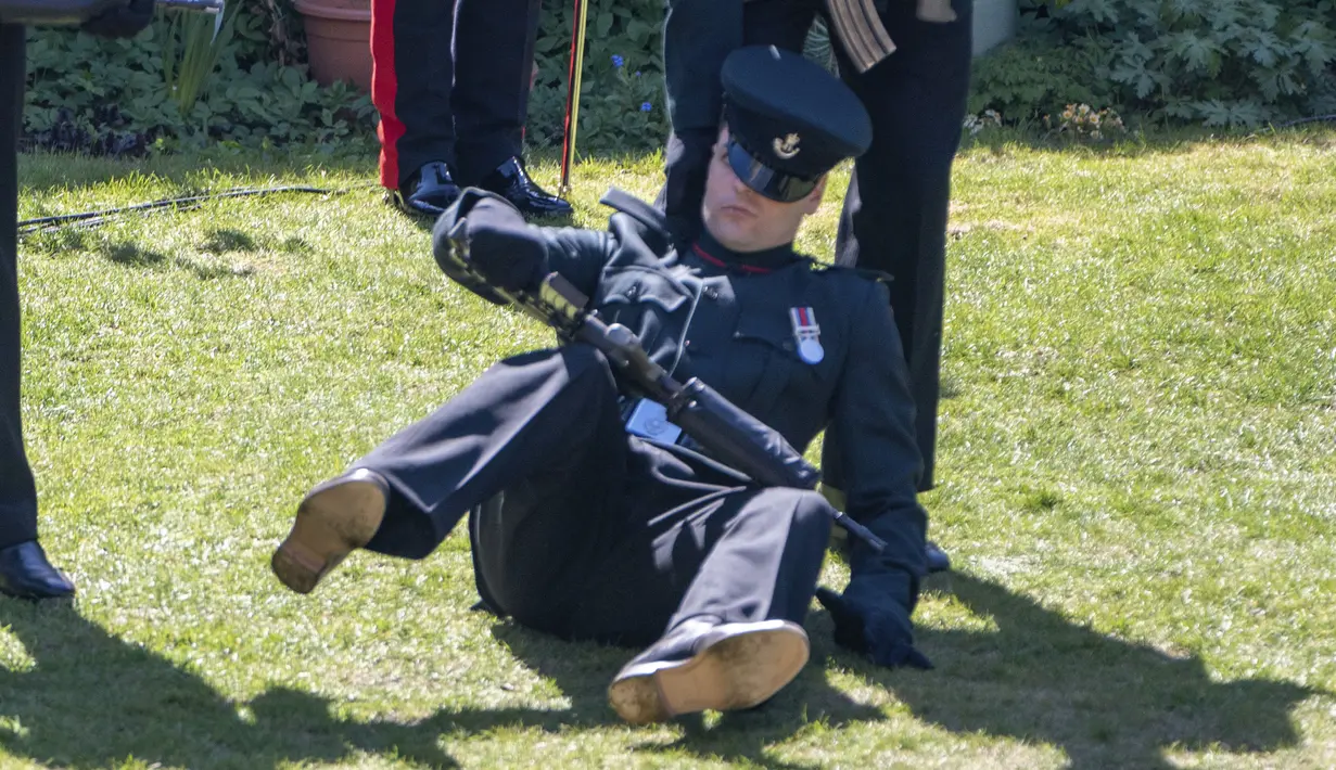 Seorang anggota The Rifles terjatuh menjelang pemakaman Pangeran Philip di luar Kapel St George di Kastil Windsor, Windsor, Inggris, Sabtu (17//4/2021). Prajurit yang tidak disebutkan namanya itu tampak tercengang saat dia jatuh ke tanah. (Arthur Edwards/Pool via AP)