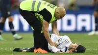 Seorang steward berbicara kepada wanita yang menyerbu ke lapangan dan mengganggu pertandingan final Piala Dunia 2018 antara Prancis dan Kroasia di Stadion Luzhniki, Moskow, Minggu (15/7/2018). (AP Photo / Mar